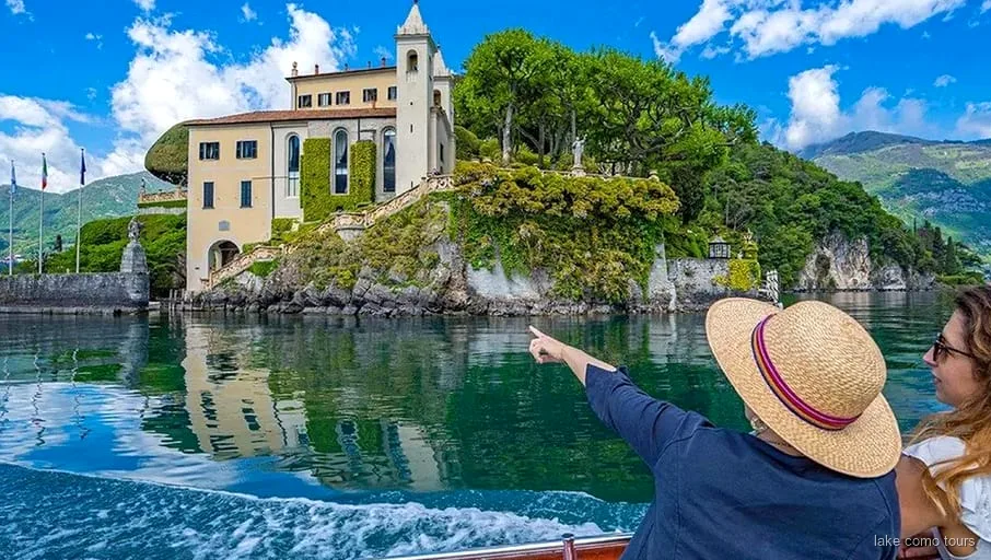 Small group boat cruise on Lake Como passing lakeside villas near Bellagio
